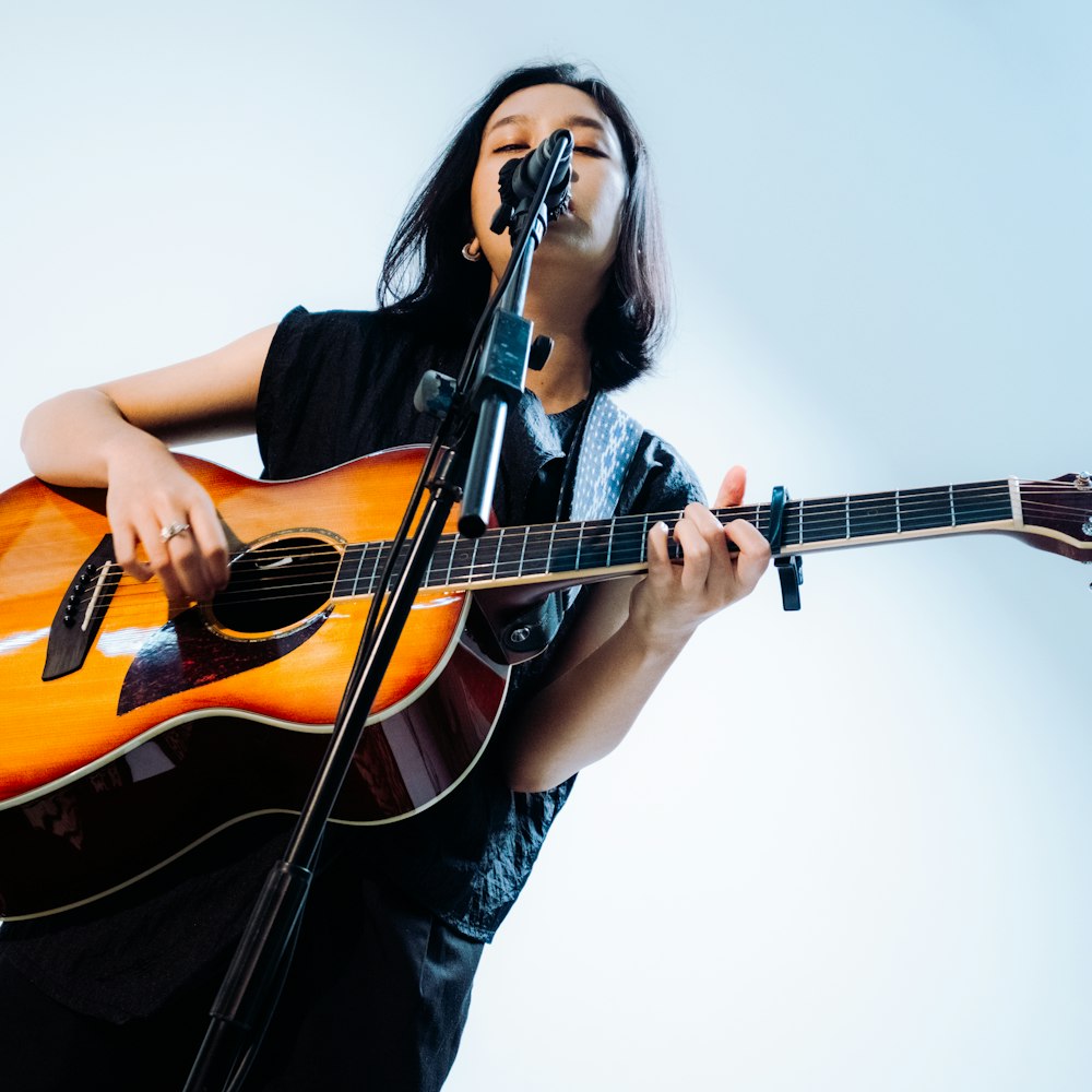 Penyanyi memainkan gitar akustik